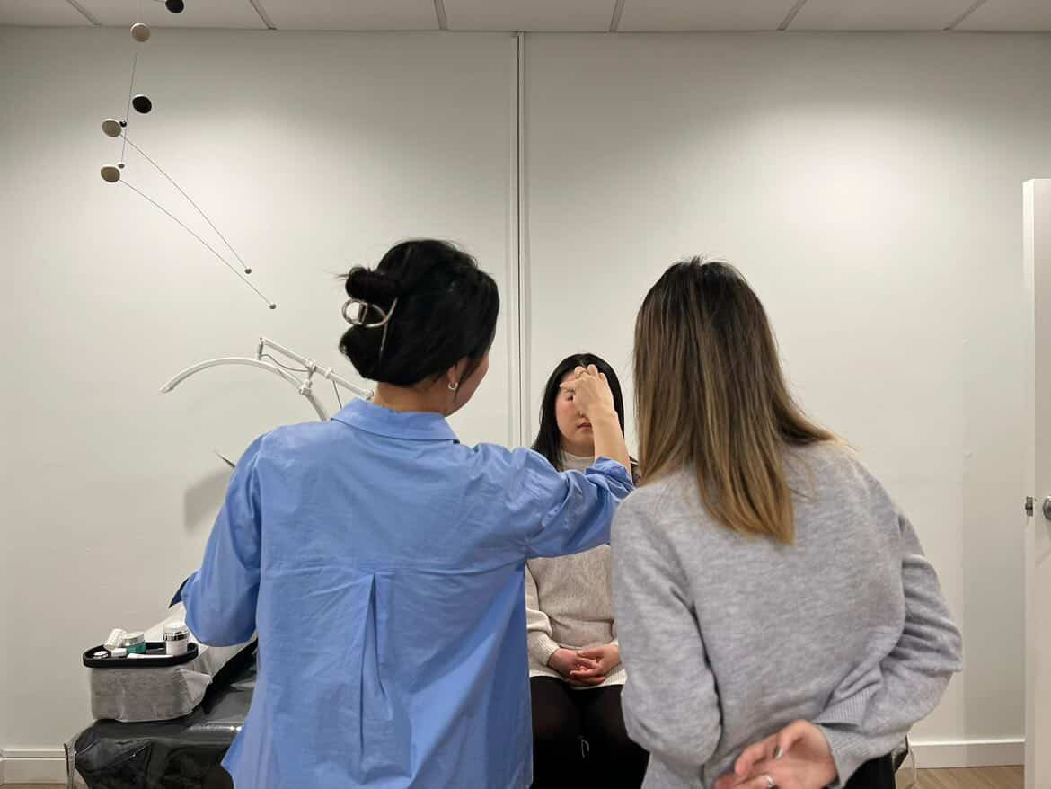 Hailey guiding a student during lash lift training